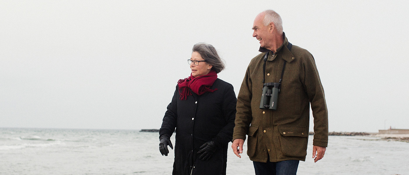 Bild-ID: sca5081. Äldre par promenerar på stranden.