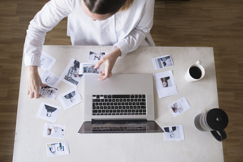 kvinna arbetar med fotografier framför laptop